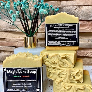 May include: A stack of four light green bars of Magic Luxe Soap, with a label that reads "Nettle & Turmeric". The soap is handcrafted with goat milk and essential oils. The net weight is 4.5 oz.