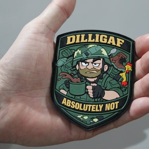 May include: A shield-shaped morale patch in olive green, black, and yellow. It features a cartoon soldier holding a coffee mug with the text DILLIGAF at the top and ABSOLUTELY NOT at the bottom. The design includes a helmet, boot, and chicken.