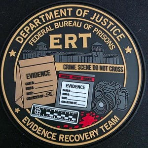 May include: A circular black and tan patch featuring the text DEPARTMENT OF JUSTICE FEDERAL BUREAU OF PRISONS ERT EVIDENCE RECOVERY TEAM. It depicts a prison wall, a crime scene tape, an evidence bag, a camera, a ruler, and a red blood splatter.