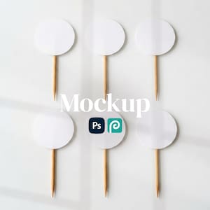 Może przedstawiać: Sześć białych, okrągłych topperów do ciast z drewnianymi patyczkami, ułożonych na białej powierzchni. Słowo "Mockup" jest wyświetlane pośrodku, wraz z logo Photoshop i Pinterest.