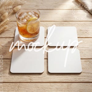 Può includere: Quattro sottobicchieri quadrati bianchi con angoli arrotondati disposti a griglia. Un sottobicchiere sostiene un bicchiere trasparente riempito con una bevanda color ambra, cubetti di ghiaccio e una fetta di limone. I sottobicchieri sono vuoti e opachi.