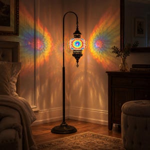 May include: A floor lamp with a mosaic glass shade, casting a rainbow pattern on the wall. The lamp has a dark metal frame and a round base. The shade is a mix of colorful glass pieces.