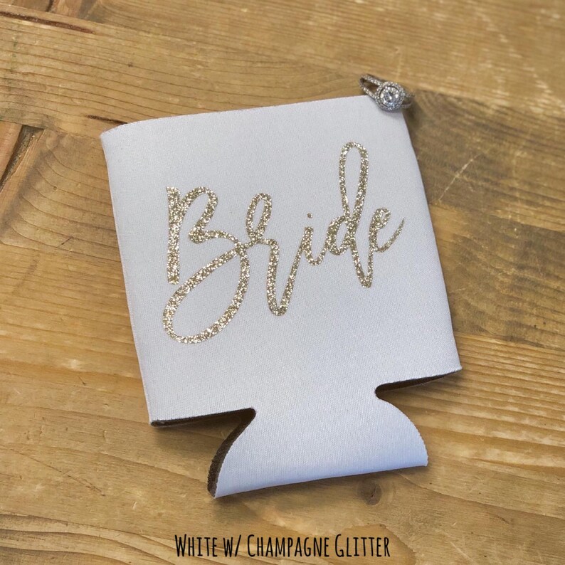 Puede incluir: Enfriador de latas blanco con la palabra "Bride" en letras de purpurina dorada.