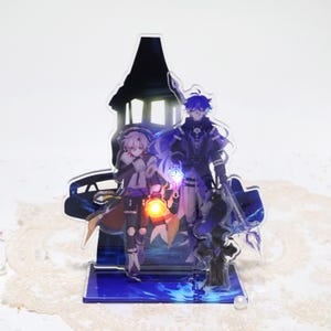 May include: Acrylic stand featuring two anime-style characters in a fantasy setting. One character holds a glowing lantern, the other a glowing sword. The stand has a blue base and a silhouette of a building in the background. The characters are in shades of purple, white, and black.