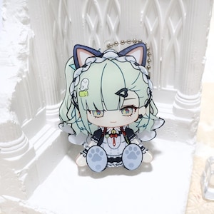 May include: A colorful anime-style keychain featuring a character with light green hair, cat ears, and a white and black outfit. The keychain has a silver ball chain and a small ghost graphic. The character is sitting with paw-shaped feet.