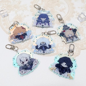 May include: A selection of seven character acrylic keyrings with silver clasps. Each keyring showcases a different anime-style character in various outfits, set against a holographic background with a star-like border. The characters have unique hairstyles and expressions.