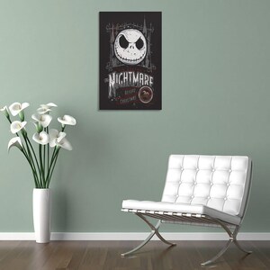 May include: A framed poster featuring Jack Skellington's face from "The Nightmare Before Christmas." The poster has a black background with white and gray text and imagery. The text reads "The Nightmare Before Christmas" and "20".