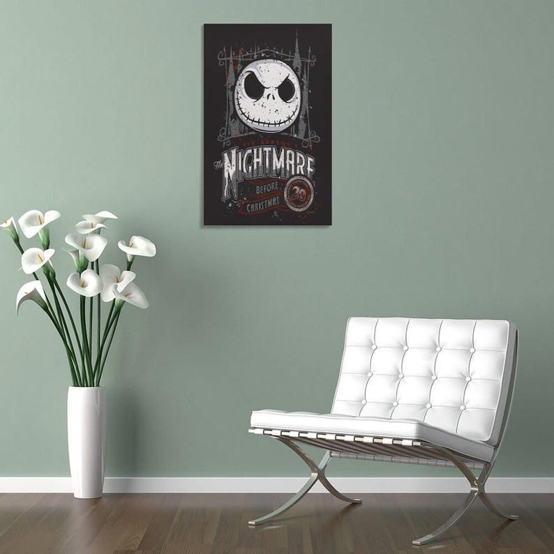 May include: A framed poster featuring Jack Skellington's face from "The Nightmare Before Christmas." The poster has a black background with white and gray text and imagery. The text reads "The Nightmare Before Christmas" and "20".