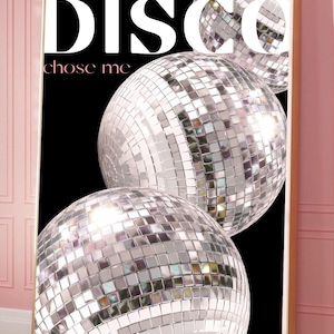 May include: A framed art print featuring three large disco balls against a black background. The word "DISCO" is displayed in large white letters, with "chose me" in smaller pink letters below. The disco balls are silver and reflective.