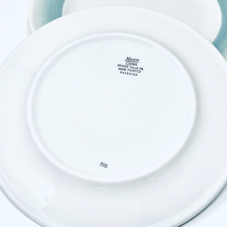 May include: White ceramic plates with a glossy finish. The underside of the plate features the text "MAYER CHINA BEAVER FALLS, PA HAND PAINTED PATENTED" and the number "355".