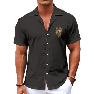 May include: A black short-sleeved button-down shirt with a notched collar and white stitching along the edges. The shirt features a gold-colored crest logo on the left chest containing the letters FB in a decorative, ornate font style.