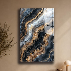 Peut inclure: Une œuvre d'art murale rectangulaire présentant un motif abstrait avec des couches tourbillonnantes de tons noirs, blancs et gris. La composition est accentuée par des veines texturées de doré métallique en diagonale.