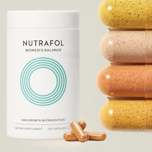 May include: A white bottle of Nutrafol Women's Balance hair growth supplement with a teal circular design. The bottle is next to a stack of capsules in shades of yellow, peach, and brown, and a few loose capsules.