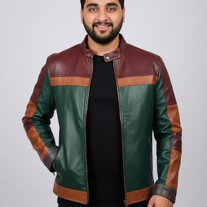 Può includere: Giacca in pelle multicolore con collo alto. La giacca presenta un design a blocchi di colore con pannelli bordeaux, marroni e verdi. Ha una chiusura con cerniera e tasche.