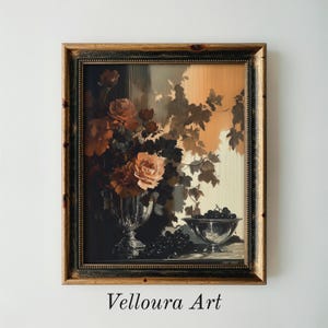 Op de afbeelding: Een ingelijste kunstdruk met een stilleven met rozen, druiven en bladeren in vintage stijl. Het kunstwerk heeft een donker, humeurig kleurenpalet met tinten bruin, oranje en zwart. De tekst "Velloura Art" staat onderaan.
