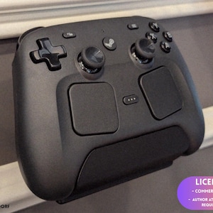 Puede incluir: Un mando de juegos negro con una cruceta, palancas analógicas, botones y paneles táctiles. El mando tiene un diseño elegante y ergonómico. La imagen incluye un aviso de licencia en la esquina inferior derecha.