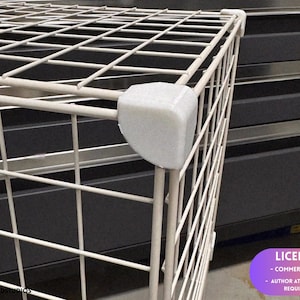 May include: A white wire grid storage cube connector featuring a sturdy plastic corner piece that joins the metal frame sections together. The white wire grid panels form a structured, open-frame cube design with a smooth, matte finish on the connector.