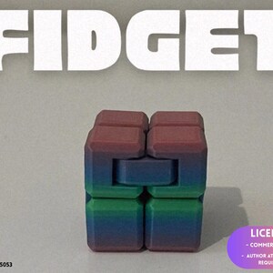 May include: A multi-colored fidget cube toy featuring a gradient transition from deep red at the top to blue and green at the bottom. The object is composed of several interconnected square blocks that can be folded and manipulated. The word FIDGET is printed in large white letters above the cube.