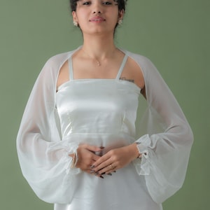 May include: A set of three ceramic mugs with a speckled, matte finish. The mugs are in shades of cream, light gray, and dark gray. Each mug has a simple, minimalist design and a rounded handle.