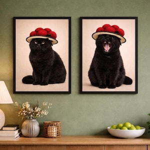 May include: Two framed art prints featuring black cats wearing hats adorned with red pom-poms. One cat sits with a stern expression, while the other yawns widely. The artwork is displayed on a green wall.