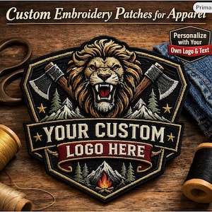 Puede incluir: Un parche de bordado personalizado para ropa con la cabeza de un león rugiente, hachas, montañas y el texto "YOUR CUSTOM LOGO HERE". El parche es negro, dorado y marrón con forma de escudo. También se ve el texto "Personaliza con tu propio logotipo y texto".