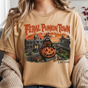 ハロウィーンタウンの野良アライグマTシャツ、レトロなパンプキンパッチセーター、パンプキンタウンのトラッシュパンダTシャツ、不気味な秋のコテージコアハロウィンTシャツギフト