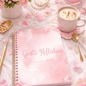 May include: A pink journal with the words "Gentle Reflections" and "A soft space for the heart" on the cover. The journal is next to a cup of coffee, a gold spoon, and a bouquet of pink roses. Pearls and a candle are also visible.