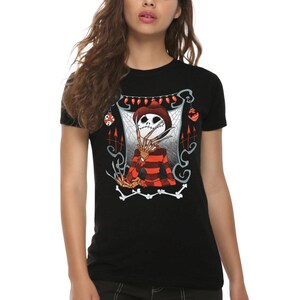 May include: A black short-sleeved t-shirt featuring a graphic print of a skeletal figure wearing a brown fedora and a red and black striped sweater. The figure has long, sharp metal blades on its fingers, surrounded by spiderwebs and red ornaments.