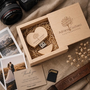 May include: A wooden heart-shaped USB drive and a wooden box with the text "Adriana Cochieci PHOTOGRAPHER". The box contains straw and a small wooden piece. A card reads "Thank you" and "FOR TRUSTING ME TO CAPTURE YOUR MEMORIES."