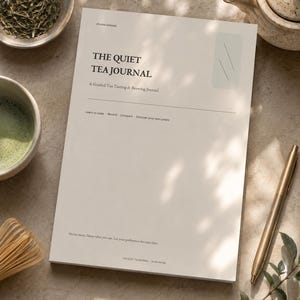 Peut inclure: Un journal en papier blanc intitulé The Quiet Tea Journal: A Guided Tea Tasting & Brewing Journal. La couverture présente du texte noir, un accent rectangulaire vert clair et les phrases Learn to taste, Record, Compare, Discover your own palate.