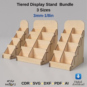 Könnte beinhalten: Ein Bündel aus drei hellen, gestuften Holz-Präsentationsständern mit mehreren Fächern. Der Text lautet: Tiered Display Stand Bundle, 3 Sizes, 3mm-1/8in, arche vectors, CDR, SVG, DXF, PDF, AI und Digital download.