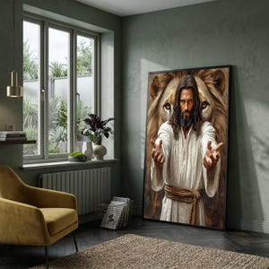 Puede incluir: Una impresión artística enmarcada representa una figura con túnicas blancas con los brazos extendidos, sobre un fondo de una cara de león. La obra de arte se exhibe en una habitación con una silla de color mostaza, una ventana y una alfombra de tonos neutros.