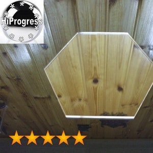 May include: A wooden ceiling with a hexagonal cutout. The cutout is made of the same wood as the ceiling and is illuminated from behind.