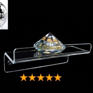 May include: A clear acrylic wall-mounted shelf with a front guard rail, featuring a large faceted glass diamond-shaped paperweight resting on its surface. The logo HiProgress is visible in the top left corner, and five orange stars are below.