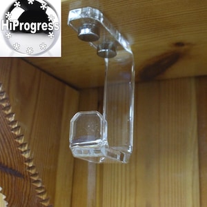 May include: A clear, J-shaped acrylic shelf bracket with two silver-colored mounting studs. The bracket is designed to be mounted on a wooden surface. The image also includes a logo with the text "HiProgress".