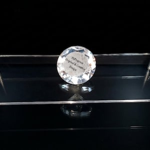 May include: A rectangular clear acrylic display stand supported by four silver-toned metal cylindrical legs. A circular, faceted clear crystal-like object sits on the center of the platform, featuring the text HiProgress Original & Creative Design.