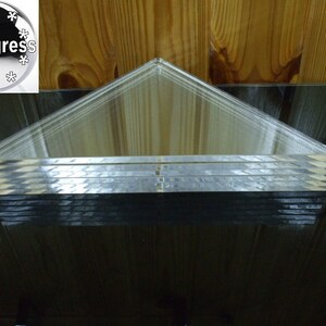 May include: A stack of clear acrylic triangular prisms. The prisms are stacked on top of each other, creating a layered effect.