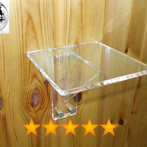 May include: A clear acrylic shelf mounted on a wood wall with five gold stars below it.
