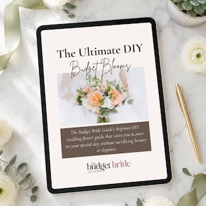 Op de afbeelding: Een digitale tablet toont een gids getiteld "The Ultimate DIY Budget Blooms" met een afbeelding van een bloemenboeket. De tekst promoot een doe-het-zelf trouwbloemengids voor beginners. De tablet ligt op een marmeren oppervlak met bloemen en een gouden pen.