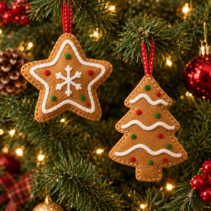 May include: Two felt Christmas ornaments shaped like a star and a tree. The star is brown with white icing outlines, a central white snowflake, and small red and green dots. The tree has white wavy lines and red and green dots.