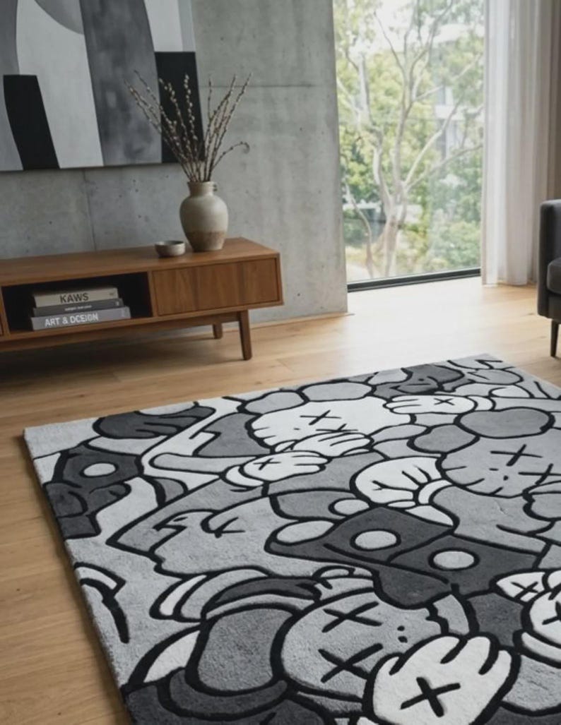 Pu&ograve; includere: Un tappeto rettangolare con un motivo grafico ripetuto nei toni del nero, bianco e grigio. Il design &egrave; composto da figure stilizzate simili a cartoni animati con occhi a forma di X e mani guantate, realizzate in uno stile illustrativo.