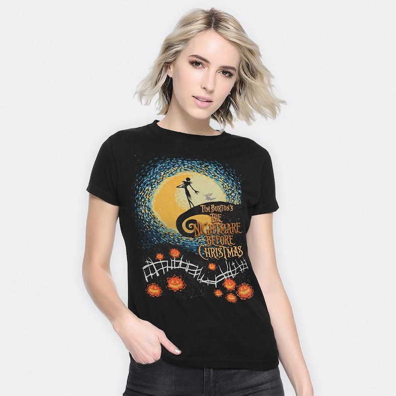 Może przedstawiać: Czarny t-shirt z grafiką z filmu Tima Burtona "Miasteczko Halloween". Projekt zawiera pełnię księżyca, Jacka Skellingtona i tytuł filmu. Koszulka ma okrągły dekolt i kr&oacute;tkie rękawy.