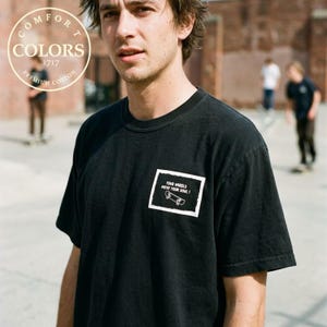 Vintage 900 Degrees Skateboard Shirt in black worn at a skatepark bowl, back print full view. Retro skate graphic tee on Comfort Colors 1717 with neon yellow 900 degree design and graffiti background. Before Everyone Called Themselves A Skater. Double sided print heavyweight skate shirt. Perfect gift for skateboarders and 90s skate culture fans who love old school street skating aesthetic