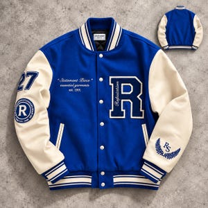 May include: A royal blue varsity jacket with cream-coloured sleeves, featuring a large letter R on the chest, the number 27 on the right sleeve, and text reading Statement Piece essential garments est. 1991. Includes a back view of the jacket.