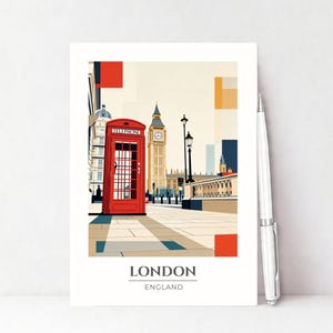 Puede incluir: Una lámina de arte rectangular con una ilustración estilizada de una cabina telefónica roja y el Big Ben en Londres, Inglaterra. La lámina incluye el texto LONDON ENGLAND en la parte inferior y está junto a un bolígrafo plateado.