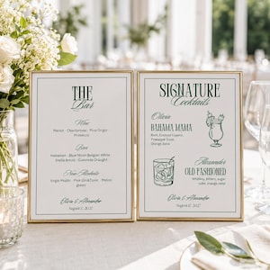 Può includere: Due insegne rettangolari verticali in sottili cornici dorate con testo verde scuro su sfondo bianco. L'insegna a sinistra elenca le bevande, mentre quella a destra mostra cocktail d'autore con illustrazioni a linee di bicchieri.