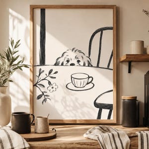 May include: A framed black and white illustration depicts a dog peeking over a table set for tea. A teacup and saucer are on the table. The scene is in a kitchen with a coffee maker, mugs, and a vase with greenery.