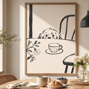 May include: A framed art print featuring a black and white sketch of a dog peeking over a table with a teacup. The artwork is in a wooden frame and is displayed in a well-lit room with a table set for breakfast.