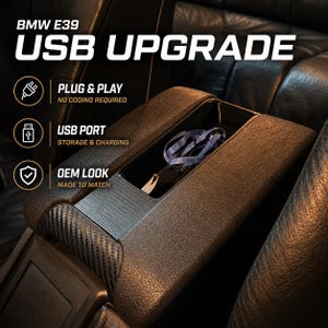 May include: A black center console armrest for a BMW E39 featuring a USB upgrade, carbon fiber texture accents, and an open storage compartment. Text on the image reads: BMW E39 USB UPGRADE, PLUG & PLAY NO CODING REQUIRED, USB PORT STORAGE & CHARGING, OEM LOOK MADE TO MATCH.