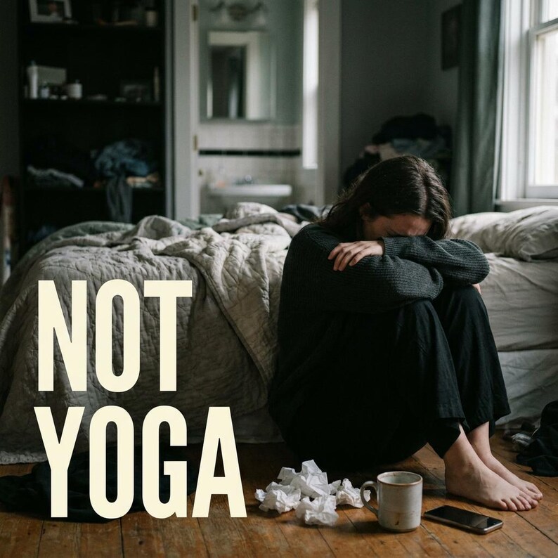 May include: A person sits on a wooden floor with their head in their arms, near a bed with a grey comforter. The text "NOT YOGA" is in large, white letters. A mug, phone, and crumpled tissues are nearby.